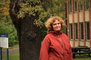 Jenny Rosendahl utanför specialpedagogiken, Stockhols universitet. Träd medhöstfärger i bakgrunden.
