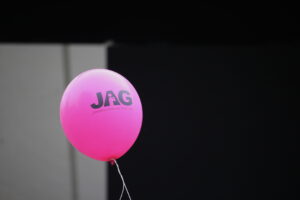 En rosa JAG-ballong mot svartgrå bakgrund.